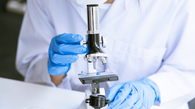 A technician looking at a microscope