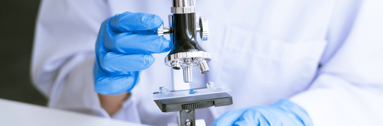 A technician looking at a microscope