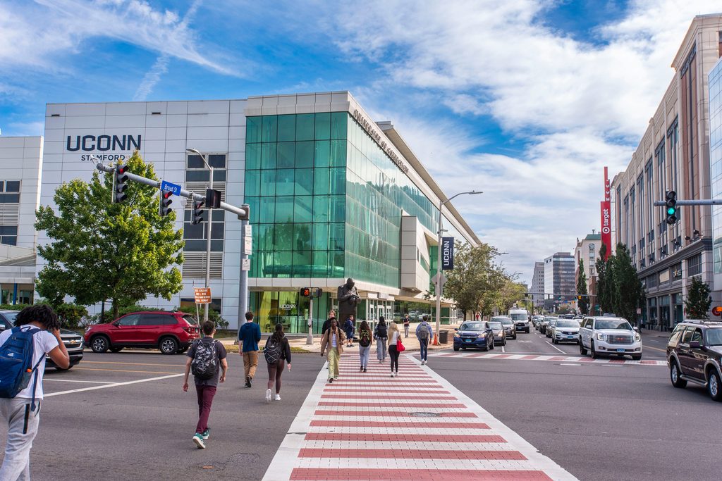Students crossing the sidewalk to go to the UConn Stamford building