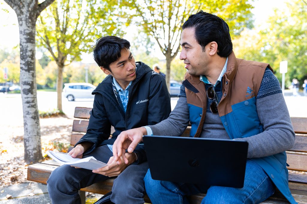 Two students chatting on a bench