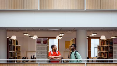 Two students talking in a university library