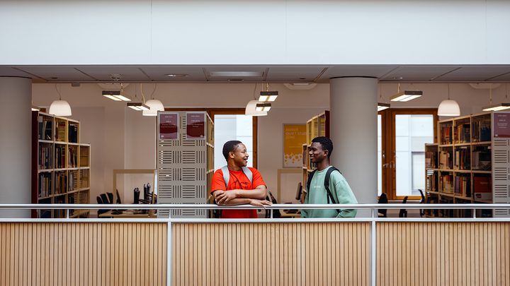 Two students talking in a university library