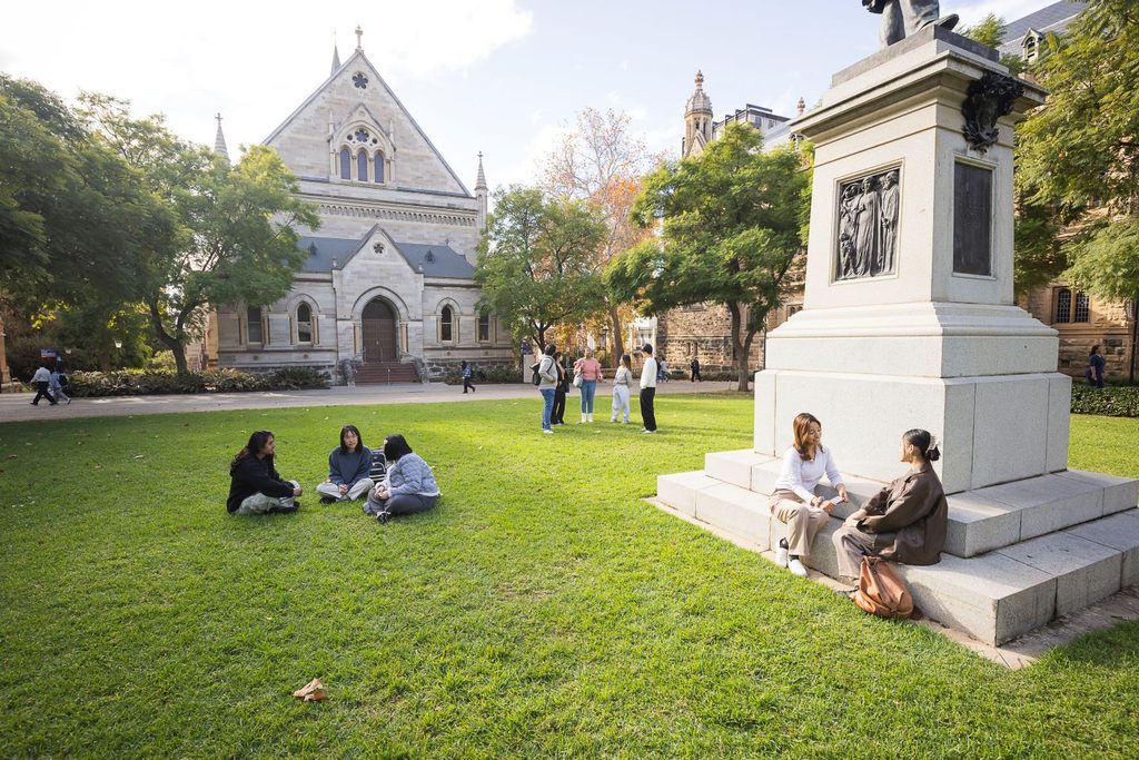 Students laying in the grass and chatting