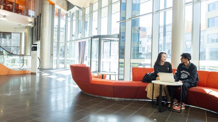 Students sitting in the hall of the campus