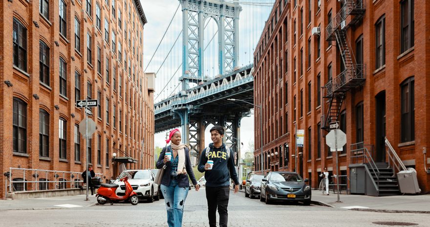 Shubham and Bulie walk down the street in DUMBO, New York City