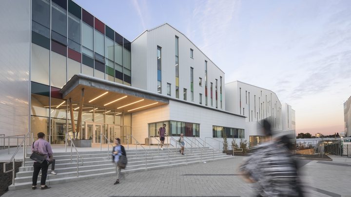 Emily Carr University campus building exterior with students entering and leaving the main entrance.
