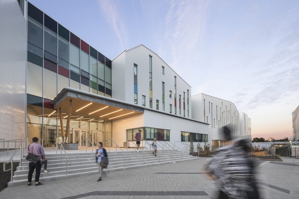 Emily Carr University campus building exterior with students entering and leaving the main entrance.