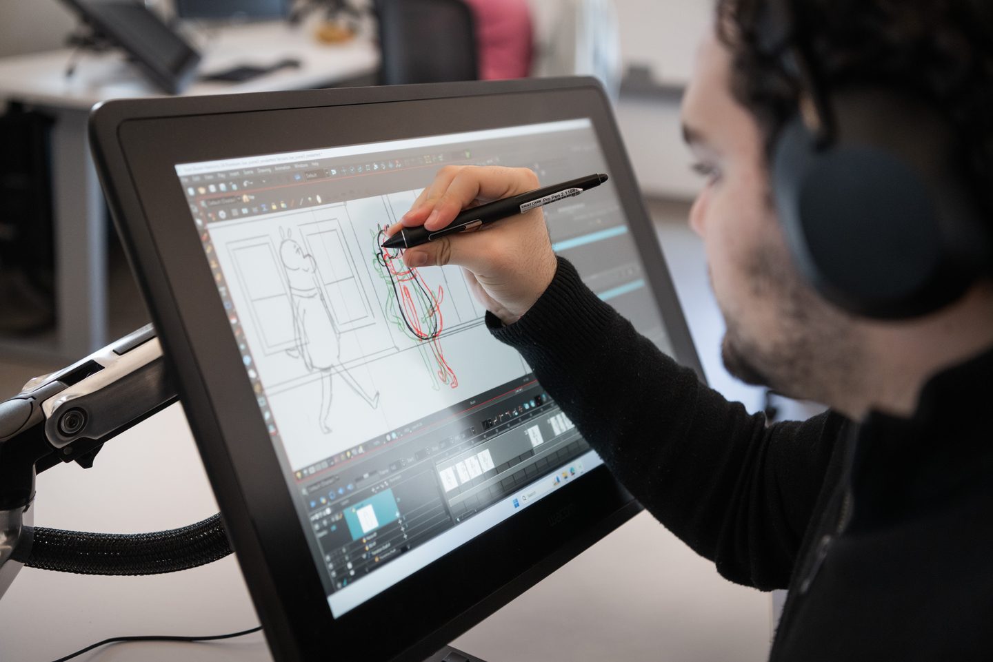Student creating digital animation artwork on a drawing tablet in an animation studio at Emily Carr University.