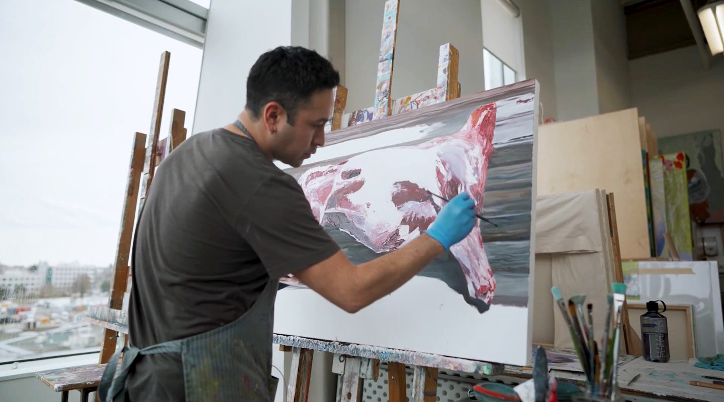Student creating a painting in an art studio at ECU
